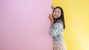 heureuse étudiante jeune fille avec un fond rose et jaune. photo