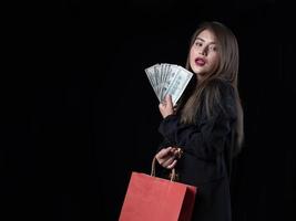 une belle femme asiatique en costume noir est heureuse après avoir fait du shopping photo