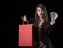 une belle femme asiatique en costume noir est heureuse après avoir fait du shopping photo