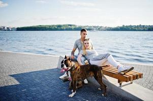 couple amoureux de deux chiens pit bull terrier contre la plage. photo