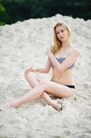 portrait d'un magnifique modèle de jeune fille posant sur la plage de sable à côté du lac. photo