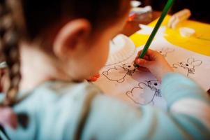 préparation au concept de pâques. petite fille dessinant un lapin. photo