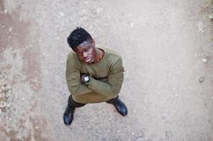 séduisant jeune homme afro-américain en vêtements décontractés debout sur le chemin de terre. photo