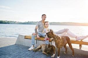 couple amoureux de deux chiens pit bull terrier contre la plage. photo