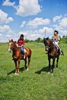 remorquer de jolies jeunes filles à cheval sur un champ aux beaux jours photo