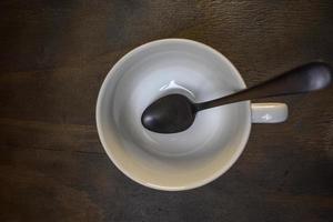 tasse de café vide avec cuillère sur fond sombre rustique photo