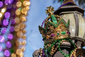 Couronne de mardi gras en plein air et perles sur lampadaire au soleil photo