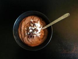 bol de smoothie au chocolat avec noix de coco, graines de chia et éclats de cacao