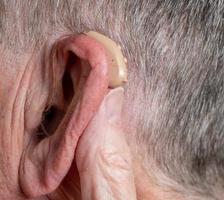 gros plan d'une petite prothèse auditive moderne derrière l'oreille photo