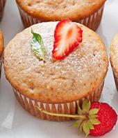 Muffin aux fraises sur une plaque blanche avec une fraise fraîche photo