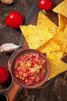 Croustilles de nacho mexicaines et trempette de salsa dans un bol sur fond de bois photo