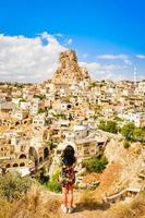 Vue arrière vertical Caucasian young female tourist en robe avec capture smartphone Château d'Ortachisar en vacances photo