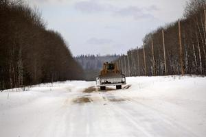 Bulldozer sur route couverte de neige en hiver photo