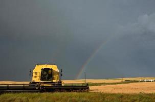 Arc-en-ciel derrière la moissonneuse-batteuse en stationnement en Saskatchewan photo