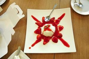 Dessert de gelée molle de panna cotta aux fraises à la vanille douce italienne sur une table en bois photo