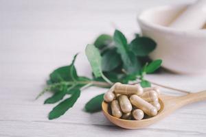 médecine alternative capsule bio à base de plantes avec des suppléments naturels de feuilles d'herbes pour une bonne vie saine. photo