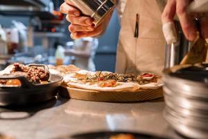 chef masculin préparant la focaccia sur le comptoir de la cuisine dans une luxueuse maison de vacances photo