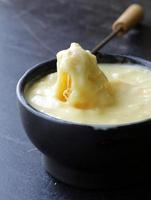 fondue - un morceau de pain (croûtons) dans du fromage liquide photo