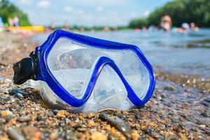 un masque de natation se trouve sur une plage publique près de l'eau sur fond de vacances photo