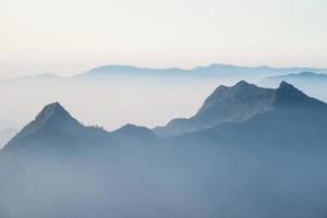 vue panoramique sur les montagnes dans le fond de la couche de brume. vue depuis phu chi fah dans la province de chiang rai en thaïlande. photo