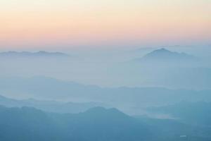 vue panoramique sur les montagnes dans le fond de la couche de brume. vue depuis phu chi fah dans la province de chiang rai en thaïlande. photo