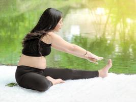 belles femmes enceintes assises dans le parc et se détendre avec de l'exercice pour une bonne santé photo