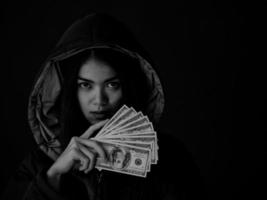 une jeune femme montre une grande partie de l'argent qu'elle a gagné en utilisant des méthodes pour rechercher des informations