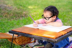 une petite fille est assise sur le tissu et peinte sur le papier posé sur une table photo