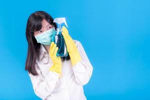 les femmes asiatiques doivent utiliser des masques pour prévenir la pollution par la poussière et prévenir l'infection par des virus qui se propagent dans l'air en nettoyant à l'aide d'un vaporisateur d'alcool photo