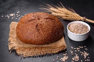 pain brun frais cuit au four avec des oreilles et des grains de blé photo