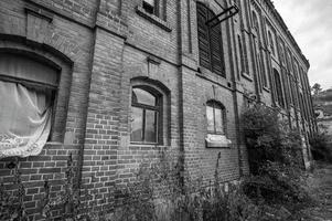 une photo en niveaux de gris de maisons abandonnées en ruines