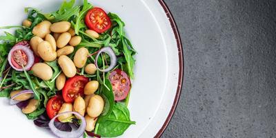 Salade de haricots tomate, oignon, feuilles de laitue mélanger des repas de légumes frais et sains collation diététique sur la table copie espace arrière-plan alimentaire