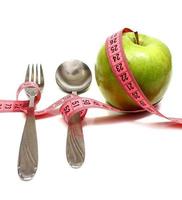la fourchette de cuillère et la pomme sont enfilées par un ruban pour mesurer le régime alimentaire photo