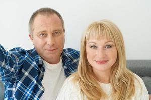 autoportrait d'un couple mature à l'intérieur de la maison sur un canapé. photo