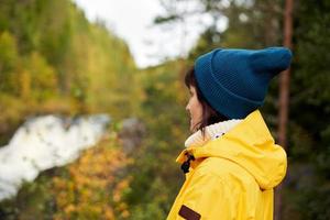 un avec la nature. vue arrière d'une femme méconnaissable regardant vers la forêt et la cascade photo