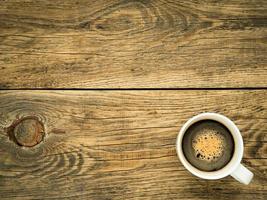 tasse brune de café mousseux sur fond en bois. photo