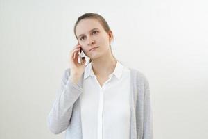 une femme calme et sans émotion parle au téléphone, écoute une autre personne, ne réagit pas. photo