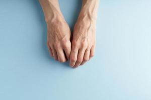 mains qui travaillent dur avec des veines saillantes sur fond bleu. photo