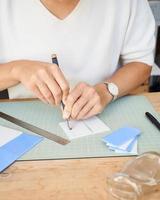 femme entrepreneure sans visage coupant du verre dans une salle de travail artisanale. photo