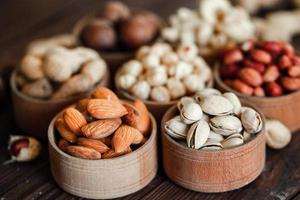 assortiment de noix pour un fond amande, noix, noix de cajou, pistaches, noisettes, cacahuètes, macadamia collection de différentes variétés de noix. composition avec des aliments sains de fruits secs. biologique. photo