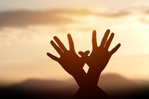 silhouette de mains féminines au coucher du soleil photo