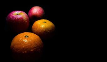 gouttelette d'eau sur une surface brillante de fraîcheur orange et pomme rouge photo