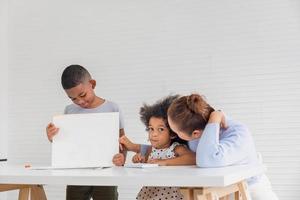 grand-mère et petits-enfants jouant joyeusement dans le salon, enfants et grands-parents dessinant ensemble des images, garçon montrant sa peinture photo