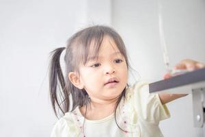 portrait d'un enfant asiatique heureux jouant dans le salon, gros plan d'une petite fille jouant avec un jouet photo