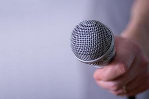 un homme tient un microphone dans sa main avec de la place pour copier. photo