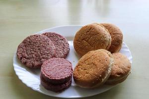 fabrication maison d'un hamburger grillé avec tomates et salade sur une assiette photo