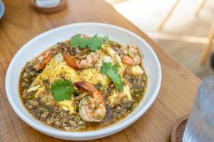 omelette crémeuse aux crevettes et à l'ail sur du riz dans une table en bois. menu délicieux et facile. photo