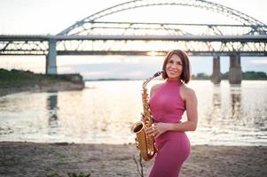 femme jouant du saxophone au coucher du soleil. photo