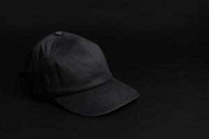 chapeau de casquette en tissu noir sur fond noir foncé. photo