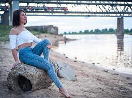 fille marchant sur la plage, contre le coucher du soleil. photo